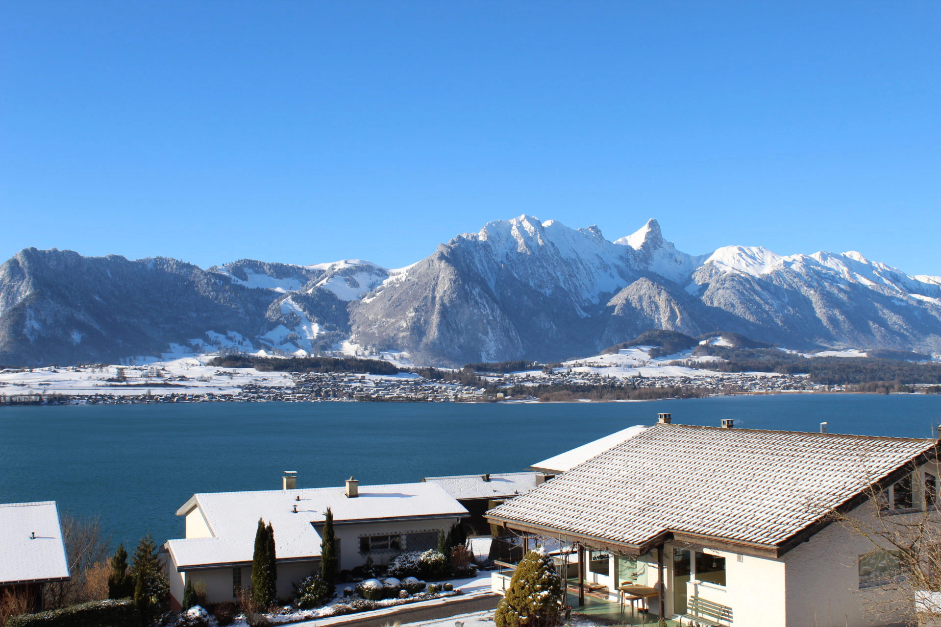 Wohnhäuser mit Seesicht am Thunersee im Winter vor der Stockhorn-Kette
